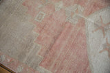 Worn, textured pile of a vintage Oushak rug showing soft blush and pale beige colors.