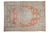 Distressed Oushak rug with faded brick red scalloped medallion on ivory abrashed ground.