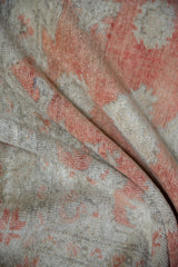 Plush distressed Oushak rug pile, featuring muted brick red and neutral ivory tones.