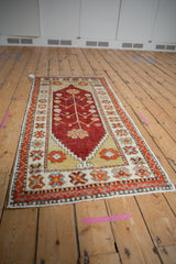 Angled view of a Turkish Oushak runner, highlighting its cherry red field and saffron spandrels.