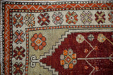 Stepped corner spandrel in cherry red and ivory floral border on a distressed vintage Oushak rug.
