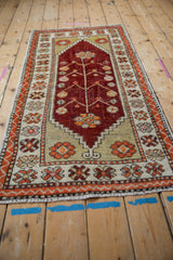 Angled perspective of the distressed Oushak runner, highlighting its cherry red field and tree of life pattern.