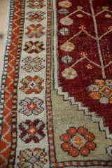 Ivory border with floral buds alongside a stepped saffron spandrel on the cherry red field.