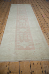 Distressed texture and intact side selvage of a vintage Oushak with dusty pink pattern.