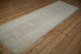 Full length view of vintage Oushak runner with distressed dusty pink quatrefoil guls.