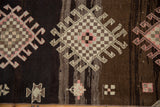 Distressed Kars runner with geometric hook and latch motifs in charcoal, brown, and blush pink.