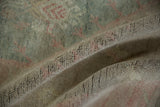 Distressed Oushak rug showing sun-faded, pebbled pile texture with deep root tones.
