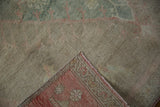 Textured pile of a vintage distressed Oushak rug, revealing deeper tones on its reverse side.