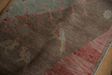 Sun-faded red border and abrashed brown field with delicate green patterns on a vintage Oushak rug.