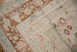 Distressed Oushak carpet with abrased pile, featuring blush and turquoise floral motifs.