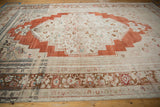 Distressed Oushak main border with meandering vine palmettes, lotus flowers, sand, and brick red.