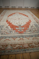 Distressed Oushak border with meandering vine, lotus flowers in brown, turquoise, blush.