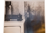 Faint 'Socrates' writing on a textured wall in the black and white photograph.