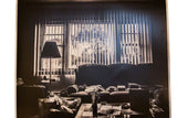 Detail of the photograph's right side, showing deep shadows over a couch and table.