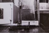 Black and white photograph print, 'Home Sweet Home' text on a raw, textured wall.