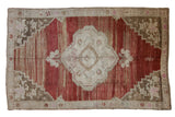 Distressed Oushak rug: cherry red abrashed field, pale medallion, floral corner spandrels, 6'9