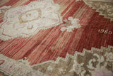 Stepped floral spandrel on distressed Oushak rug with abrashed cherry red field and number 1980.