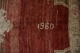 Distressed vintage Oushak rug close-up, showing cherry red abrash and painted 1980 numbers.