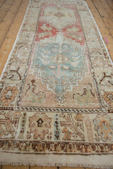 Distressed vintage Oushak runner's abrashed field, detailed floral medallion, and muted border patterns.