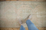 Distressed vintage Karaja runner with geometric patterns in pale pink, seafoam, and sand.