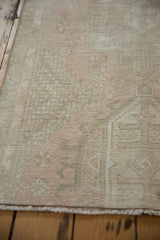 Distressed vintage Karaja rug with faded pastel tones, showing worn texture and foundation.