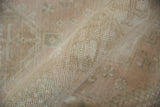 Rolled pile texture of a distressed vintage Karaja runner with muted geometric patterns.