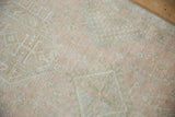 Distressed vintage Karaja runner texture, with pale pink, beige, and dusty green geometric patterns.