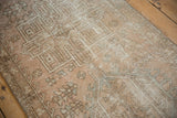 Distressed vintage Karaja runner pile showing geometric and floral motifs in faded tones.