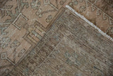 Corner of distressed Karaja runner, showing hand-knotted foundation, worn pile, and natural fringe.