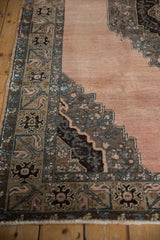 Close-up of the distressed corner spandrel with serrated leaf motifs on a vintage Turkish Oushak carpet.