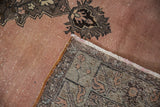 Corner of a vintage Oushak rug folded over to reveal its hand-knotted foundation and weave.