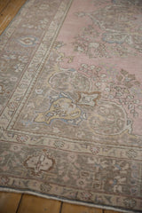 Distressed vintage Tabriz carpet, pale pink field, time-softened grey motifs, even wear with faint foundation showing.