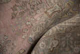 Folded vintage distressed Tabriz carpet, showcasing pale pink, dusty mauve, and slate blue gray arabesques.