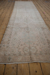 Long angle view of a vintage Sivas runner's repeating lotus palmettes and distressed, low pile.