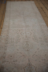 Low view along a distressed Sivas runner showing its column of faded palmettes.