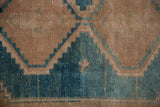 Distressed vintage Hamadan rug pile, showing serrated geometric design in dusty turquoise and camel.