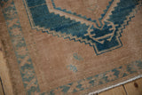 Distressed pile with dusty turquoise serrated pattern and fringe on a rug edge.
