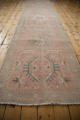 Distressed vintage Karaja runner with faded pink, blue medallion and floral motifs.