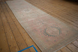 Distressed Karaja runner showing dusty turquoise geometric medallion on faded pink field.