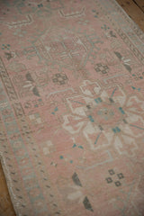Distressed vintage Karaja runner, highlighting its worn pink field with muted geometric patterns.