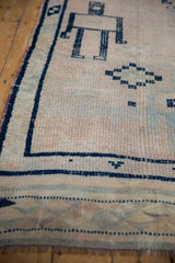 Distressed pile and cobalt blue human robot effigy on a vintage Oushak runner.