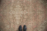 Distressed Tabriz carpet featuring faded rose pink, pale coffee, and geometric stepped medallion.