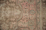 Distressed Tabriz rug detail; faded rose, coffee brown, pale green vinery with even wear.