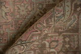 Distressed Tabriz carpet's softly worn pile shows dusty pink, pale blue, and coffee brown patterns.