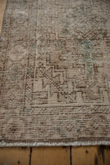 Distressed vintage Oushak rug pile with visible wear and faded geometric motifs.