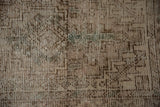 Close-up of distressed vintage Oushak rug pile with prominent wear and faded pattern.