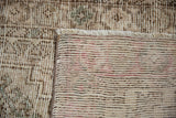 Distressed Oushak rug's worn pile, exposed knot heads, and intricate hand-knotted reverse.