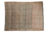 Distressed vintage Oushak rug with faded allover lattice, shifting tones of dusty peach, sand, and muted green.