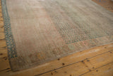 Distressed vintage Oushak carpet with heavy abrash, showing faded dusty raspberry and emerald green pattern.