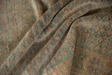 Distressed Oushak rug pile texture in faded raspberry, sand, and jade green.